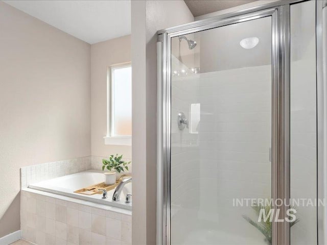 full bathroom with a shower stall and a garden tub