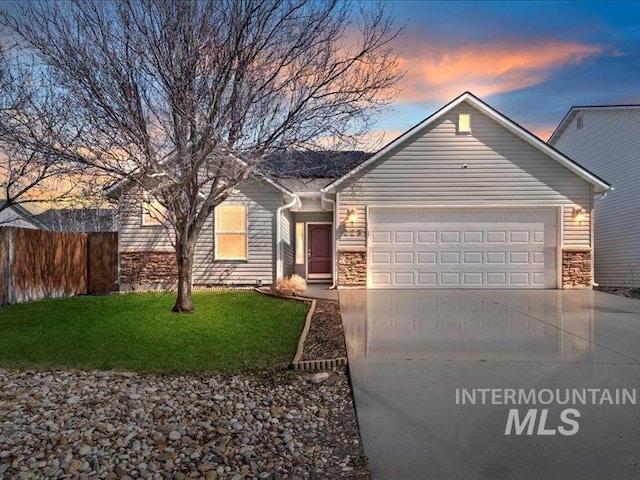 single story home featuring a lawn, driveway, stone siding, fence, and a garage
