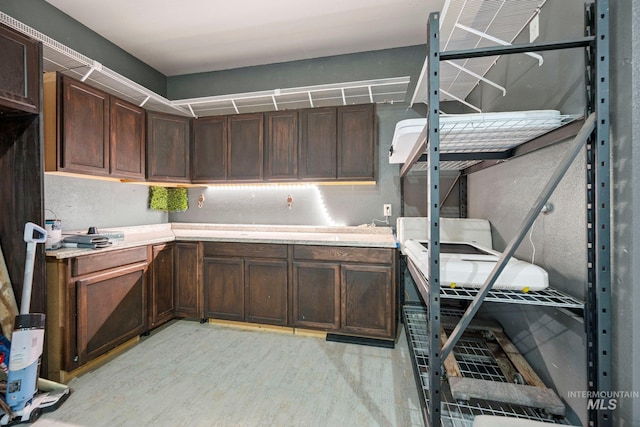interior space featuring light countertops, light wood-style floors, and dark brown cabinetry