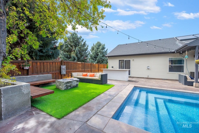 view of pool featuring a fenced in pool, fence, a yard, a patio area, and an outdoor living space with a fire pit