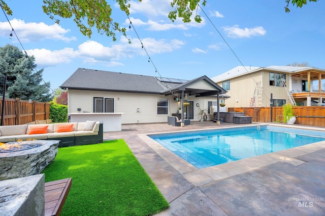 view of pool with a fenced backyard, a hot tub, a yard, an outdoor living space with a fire pit, and a fenced in pool