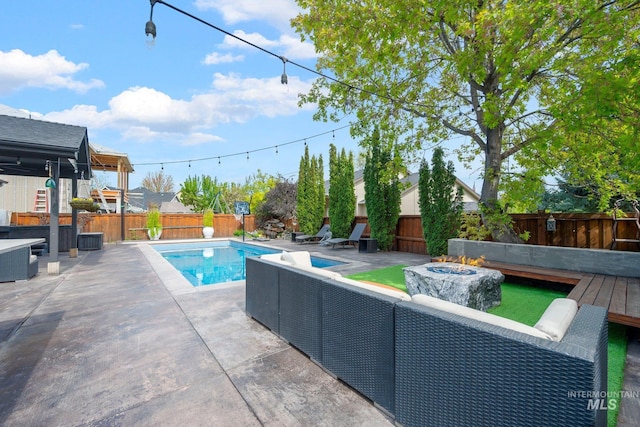 view of pool with a fenced backyard, a fenced in pool, an outdoor living space with a fire pit, and a patio