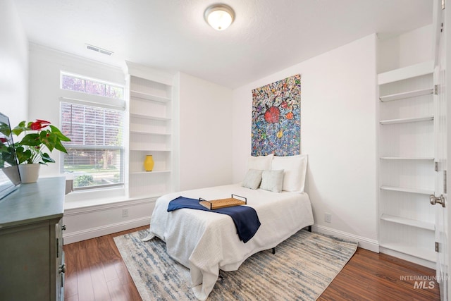 bedroom featuring baseboards, visible vents, and dark wood-type flooring