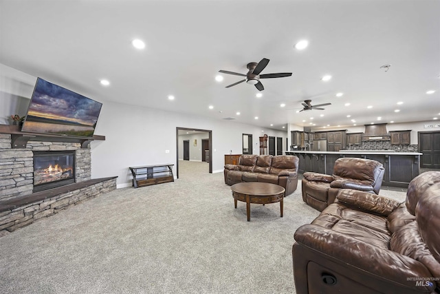 living area with baseboards, ceiling fan, light carpet, recessed lighting, and a fireplace