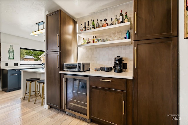 2402 Columbus, Boise, ID 83705 - indoor dry bar featuring wine cooler, tasteful backsplash, and light wood-style floors