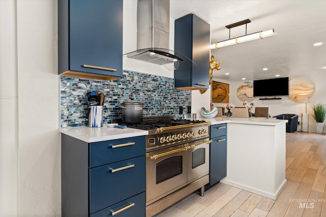 2402 Columbus, Boise, ID 83705 - kitchen with double oven range, wall chimney range hood, blue cabinetry, tasteful backsplash, and light countertops