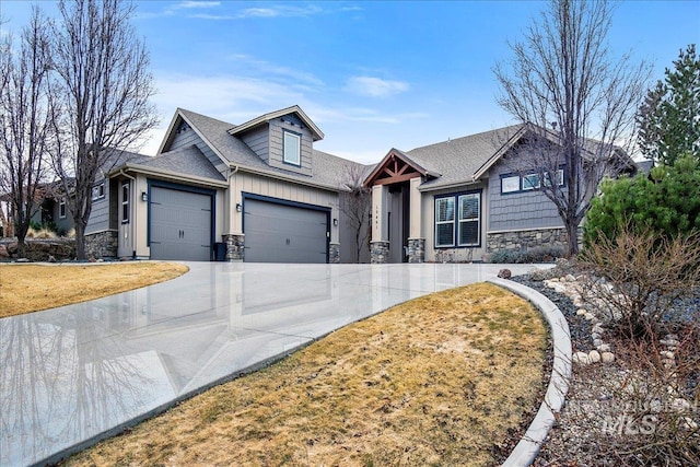 view of front of house with driveway, stone siding, roof with shingles, an attached garage, and board and batten siding