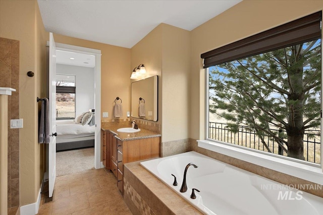 ensuite bathroom with tile patterned floors, vanity, a bath, and ensuite bathroom