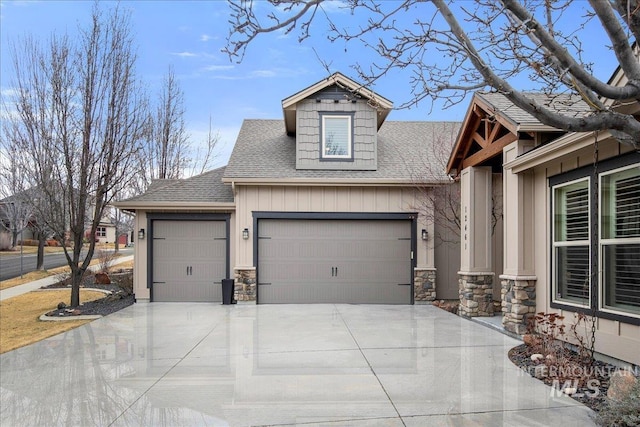 exterior space with an attached garage, a shingled roof, concrete driveway, stone siding, and board and batten siding