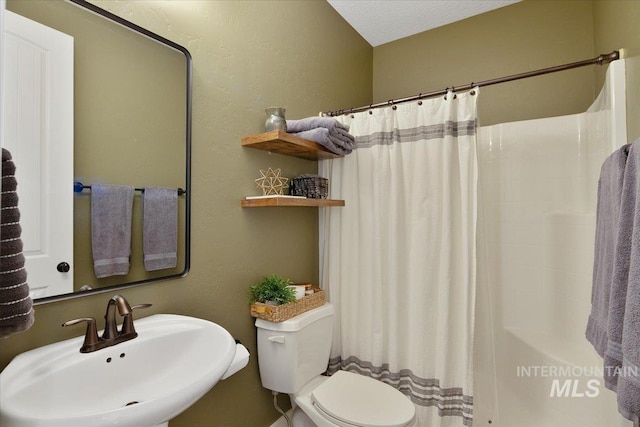 bathroom with a sink, toilet, and a shower with curtain