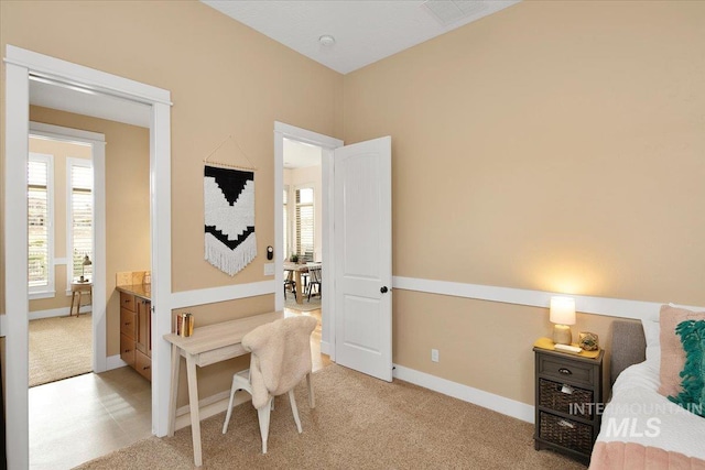 bedroom with light colored carpet and baseboards