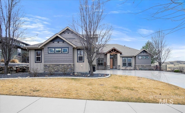 craftsman house with stone siding and a front yard