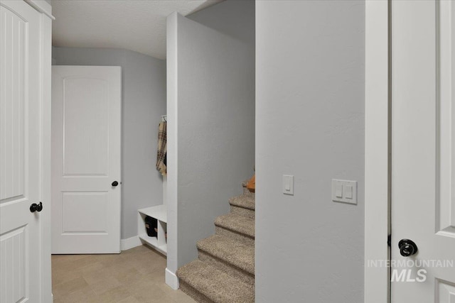 stairs featuring baseboards and tile patterned floors