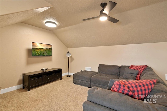 living room with a textured ceiling, light carpet, visible vents, baseboards, and vaulted ceiling