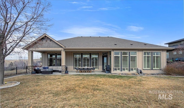 rear view of house with a yard, a patio, an outdoor hangout area, board and batten siding, and fence