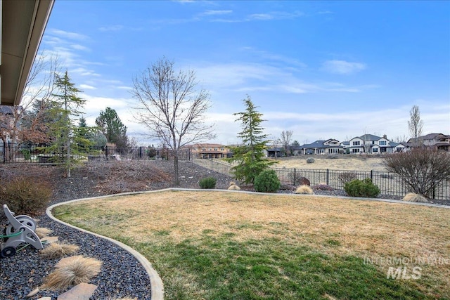 view of yard featuring a fenced backyard and a residential view