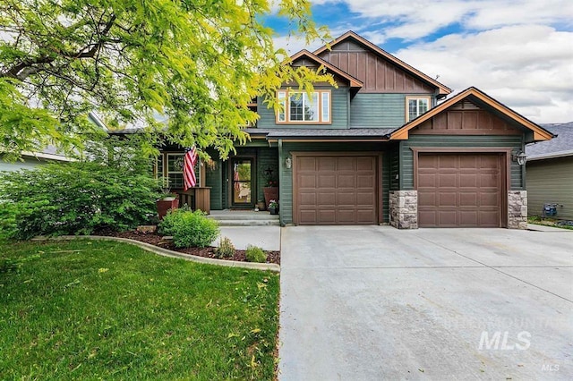 craftsman-style home featuring concrete driveway, board and batten siding, stone siding, and a front lawn