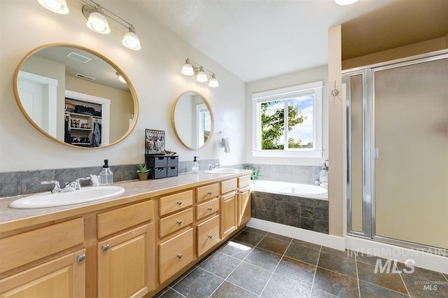 full bathroom with a shower stall, a garden tub, visible vents, and a sink