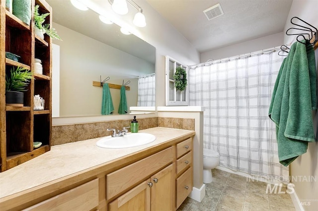 bathroom with tile patterned flooring, visible vents, curtained shower, toilet, and vanity