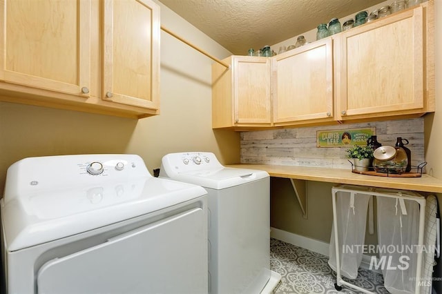 laundry area featuring cabinet space, separate washer and dryer, and a textured ceiling