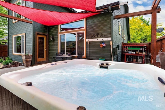 view of patio / terrace featuring a hot tub and fence