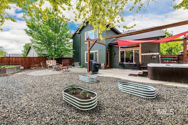 back of house with a patio area, fence, and a hot tub