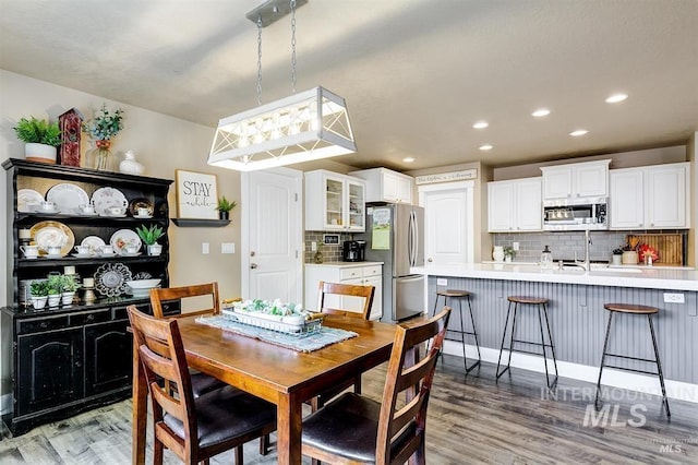 dining room with recessed lighting and light wood-type flooring