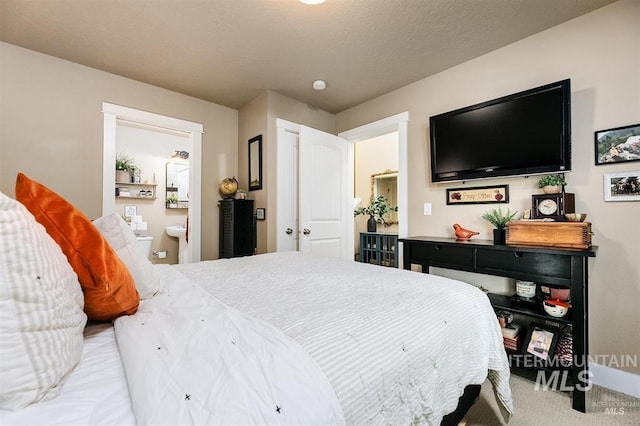 carpeted bedroom with ensuite bathroom