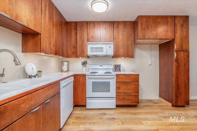 1134 N Camelot Dr, Boise, ID 83704 - kitchen featuring white appliances, brown cabinetry, and light countertops