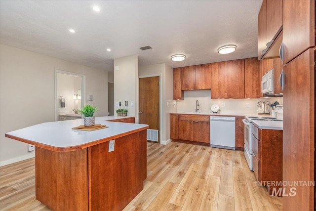 1134 N Camelot Dr, Boise, ID 83704 - kitchen with white appliances, brown cabinets, light wood-style flooring, light countertops, and recessed lighting