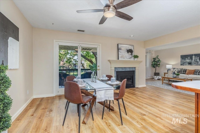1134 N Camelot Dr, Boise, ID 83704 - dining space featuring a fireplace, light wood-style flooring, and a ceiling fan