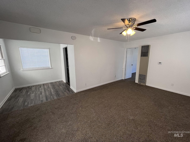 unfurnished room featuring a ceiling fan, baseboards, dark carpet, and a textured ceiling