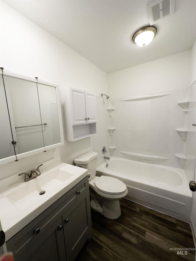 bathroom with visible vents, toilet, washtub / shower combination, vanity, and wood finished floors