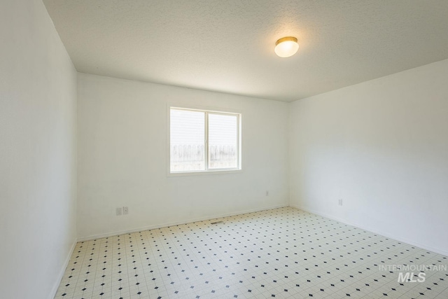 4709 Pioneer Ave, Caldwell, ID 83607 - unfurnished room with baseboards, light flooring, and a textured ceiling