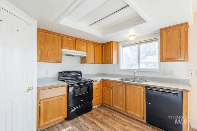 4709 Pioneer Ave, Caldwell, ID 83607 - kitchen with black appliances, a sink, under cabinet range hood, light wood-style flooring, and light countertops