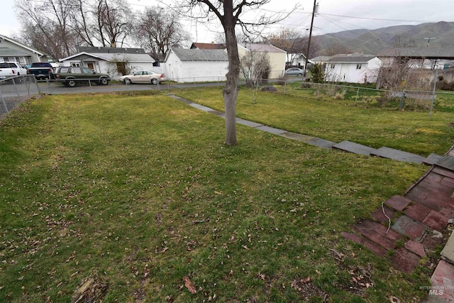 view of yard with a mountain view, a residential view, and fence