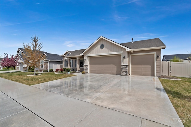 view of front of home featuring an attached garage, driveway, a front lawn, and fence
