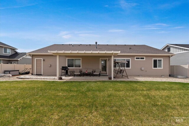rear view of house with a lawn, a patio, and fence