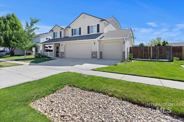 traditional home featuring driveway, stone siding, fence, a front yard, and an attached garage