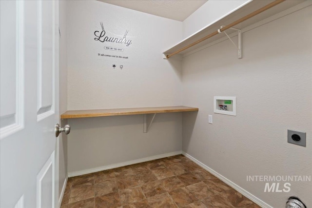 laundry room featuring electric dryer hookup, stone finish flooring, baseboards, hookup for a washing machine, and laundry area