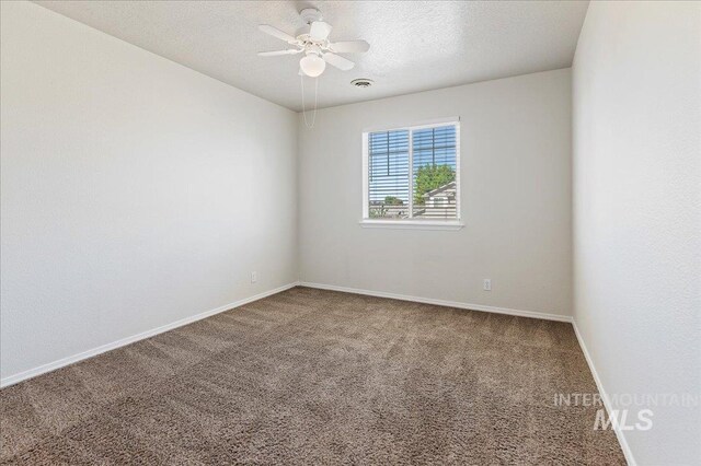 empty room with visible vents, a ceiling fan, a textured ceiling, carpet floors, and baseboards