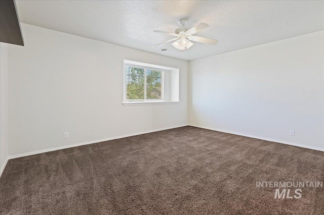 unfurnished room featuring baseboards, a textured ceiling, ceiling fan, and dark colored carpet