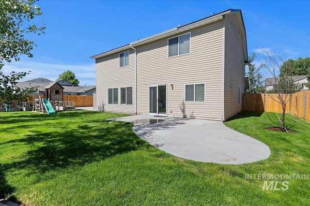 rear view of property with a patio, a playground, a yard, and a fenced backyard