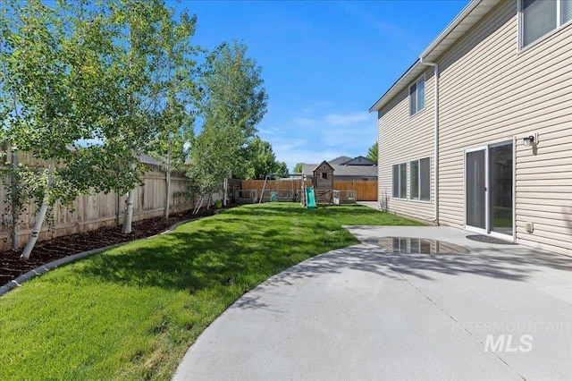 view of yard with a playground, a patio area, and a fenced backyard