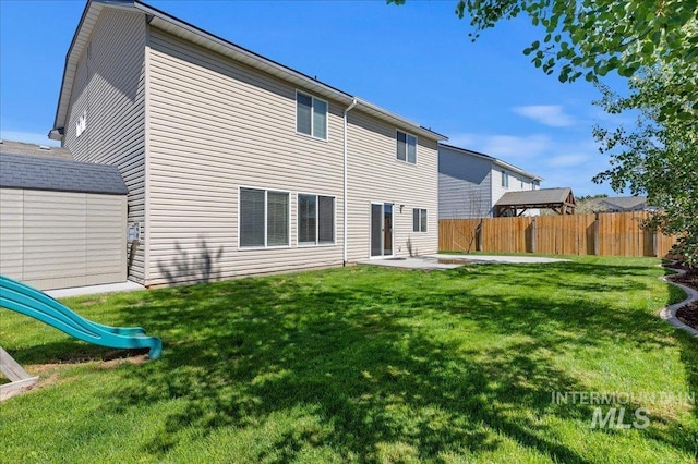 rear view of property with a patio area, a playground, a lawn, and fence