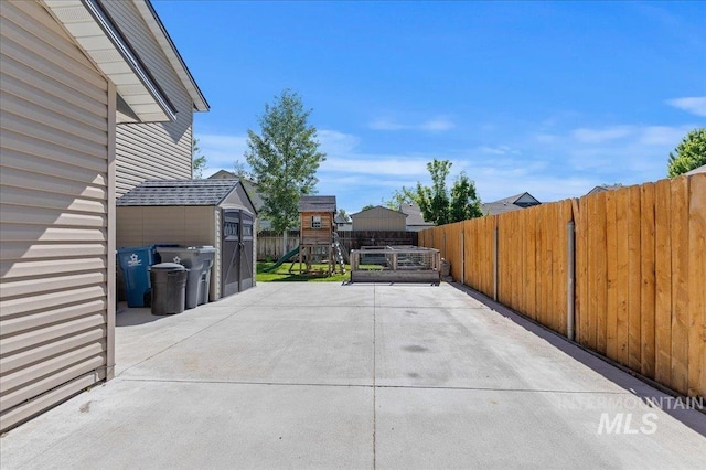 view of patio with a playground and fence