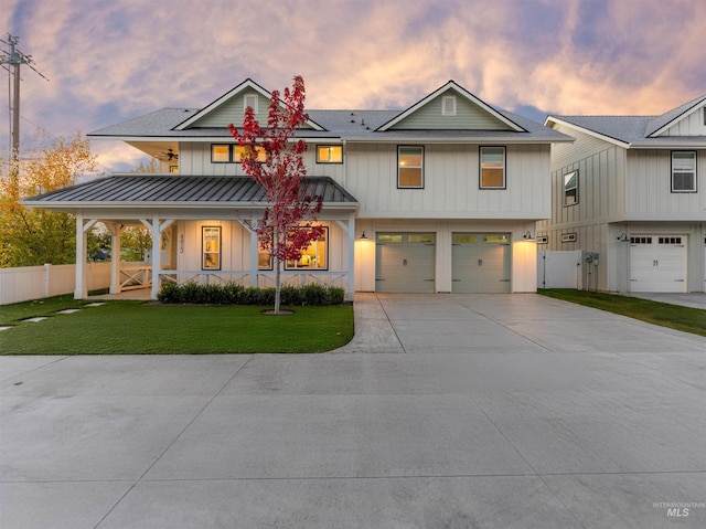 view of front of property with board and batten siding, a porch, fence, and a front lawn