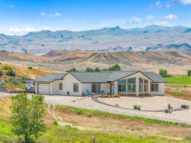 8142 US Highway 95, Marsing, ID 83639 - view of front of home with a mountain view, a sunroom, an attached garage, and driveway