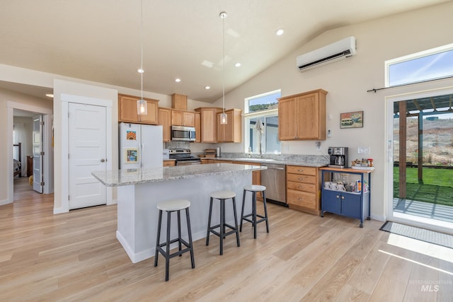8142 US Highway 95, Marsing, ID 83639 - kitchen with appliances with stainless steel finishes, a wall mounted AC, light wood finished floors, a center island, and high vaulted ceiling