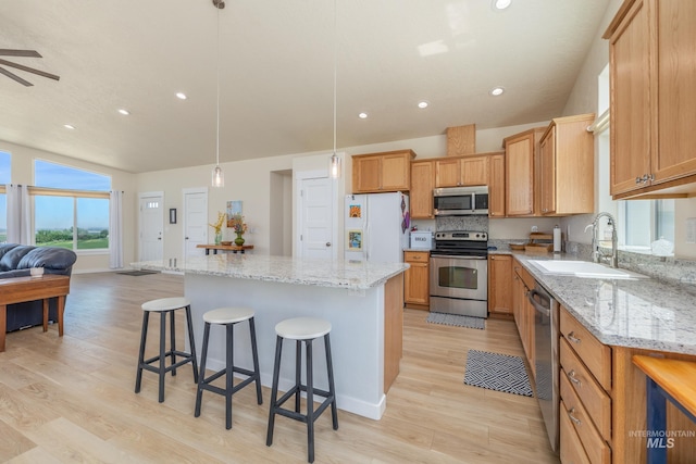 8142 US Highway 95, Marsing, ID 83639 - kitchen with appliances with stainless steel finishes, a sink, a breakfast bar, light wood-type flooring, and recessed lighting